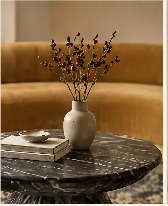 Caramel velvet sofa with a dark marble coffee table and ceramic vase